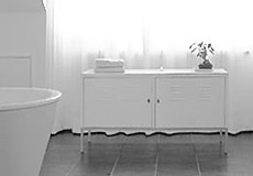 Bad mit Badewanne und Wasserklosett in Weiß. Im Hintergrund ein Schränkchen für Badeutensilien. Umbauten mit der vav Fischer-Bumiller G.b.R.
