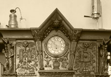 Restaurierte Holzvitrine mit betonter Uhrenädikula im Café Wacker. Sanierung und Denkmalpflege bei der vav Fischer-Bumiller G.b.R. in Frankfurt am Main.