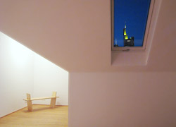 Fenster in der Dachschräge mit Ausblick auf die Commerzbank. Beispiel für Kernsanierung oder Umbau von Wohnungen in Frankfurt am Main. Bild in Farbe.