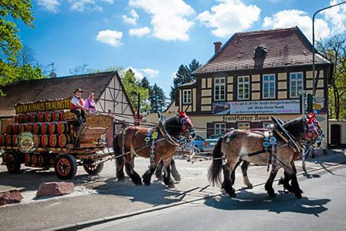 Fasslwagen und Vier-Pferde-Gespann mit Bierfässern, im Hintergrund das Frankfurter Haus.