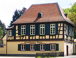 Frankfurter Haus restauriert von vav Fischer-Bumiller eGbR. Mauerwerk saniert. Mauern in Gelb, Fensterläden in Grün gestrichen.