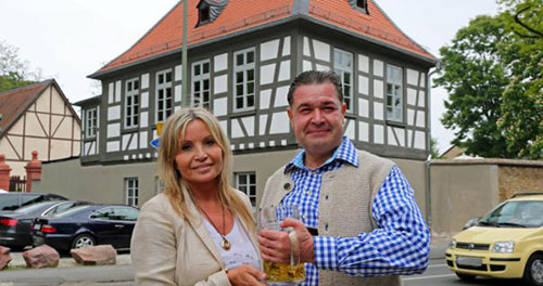 Monika Schwebel steht mit Kilian Bumiller vor dem aufwendig restaurierten Gebäude und der Schutzmauer. Foto: Leo Postl